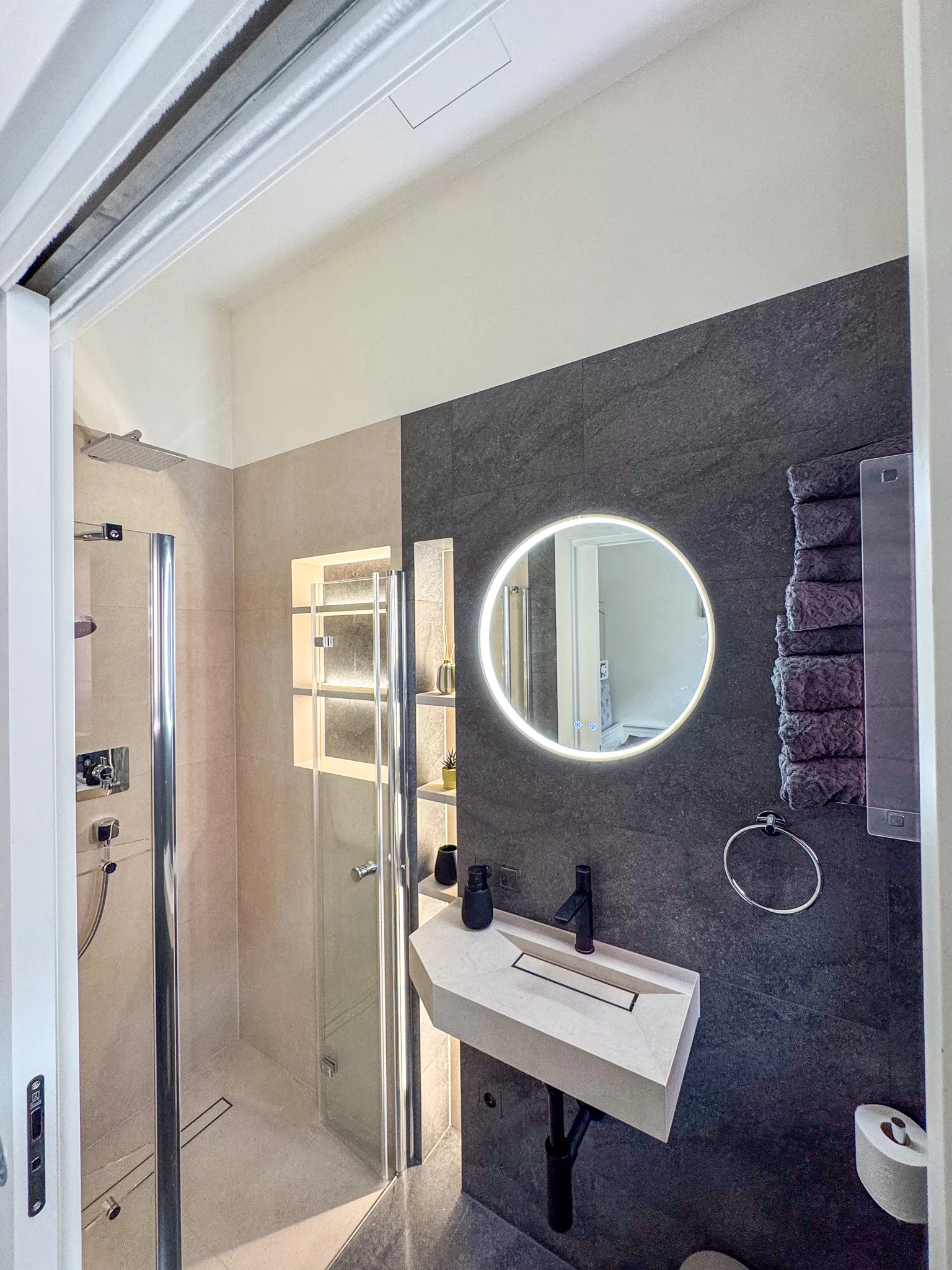 Badezimmer mit beleuchtetem Rundspiegel